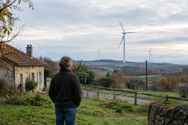 Éoliennes dans la campagne française près d’une maison raccordée au réseau électrique
